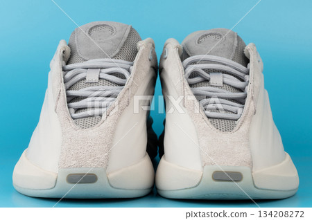 Sneakers displayed on a blue background for product viewing Sneakers displayed on a blue background for product viewing 134208272