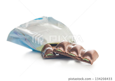Chocolate bar with pistachios cream isolated on white background. Chocolate bar with pistachios cream isolated on white background. 134208433