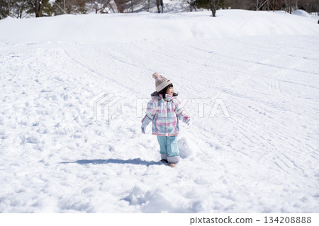 Girl walking on snowy field Girl walking on snowy field 134208888