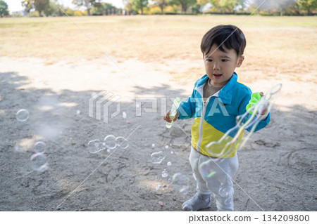 公園裡,小朋友在玩肥皂泡 公園裡,小朋友在玩肥皂泡 134209800