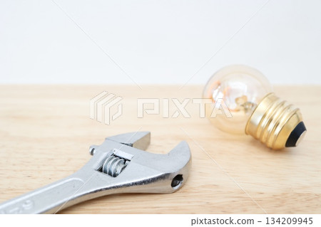 A simple image of electrical work and replacement work shown with light bulbs and tools. 134209945