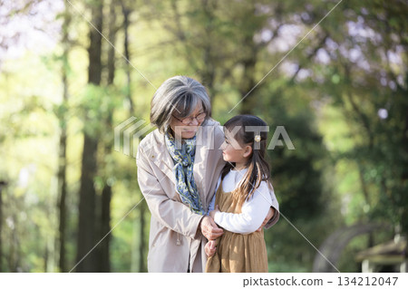Grandmother and granddaughter playing in a park with fresh spring greenery 134212047