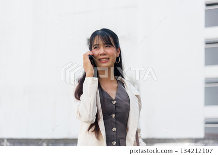 Business woman person, city travel outdoor work, street lifestyle, communicating mobile phone with happy smile, professional life connection, modern urban environment. 134212107