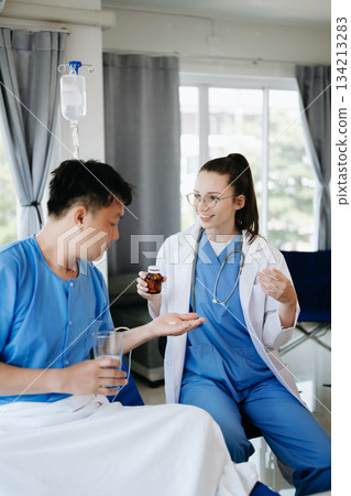 Doctor in white suit take notes while discussing and Asian elderly, man patient Doctor in white suit take notes while discussing and Asian elderly, man patient 134213283