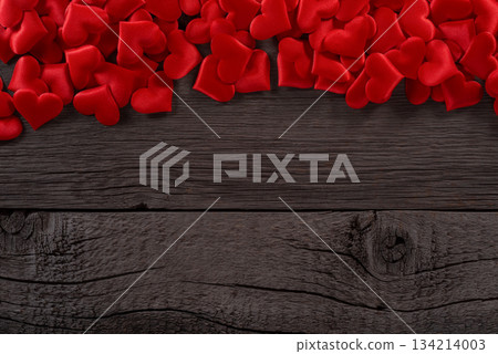 Red Hearts Scattered on Wooden Background Symbolizing Love and Passion 134214003