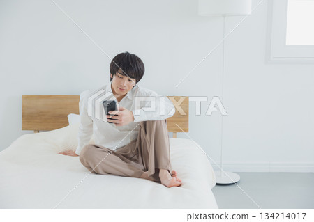 男人在床上看智能手機 134214017