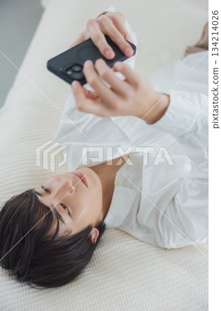 Men watching smartphones in bed Men watching smartphones in bed 134214026