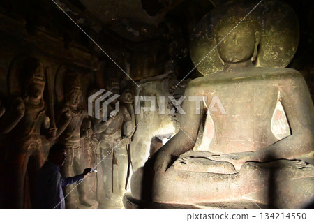 Buddha statue carved from stone at the Ellora Caves. Ellora, a UNESCO World Heritage Site, is one of the world's largest collections of rock-cut temples. Buddha statue carved from stone at the Ellora Caves. Ellora, a UNESCO World Heritage Site, is one of the world's largest collections of rock-cut temples. 134214550
