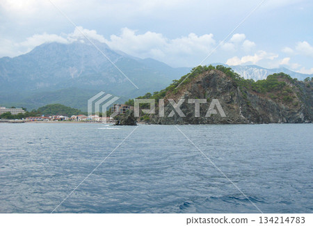 Rocky coast and sea cave on azure water clear day horizontal 134214783