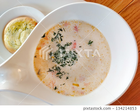Norwegian fish soup creamy salmon chowder in white bowl on wooden table horizontal 134214853