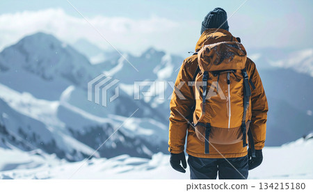 Male Hiker in Heavy Winter Jacket Looking at Snowy Mountain Range. Extreme Cold Weather 134215180