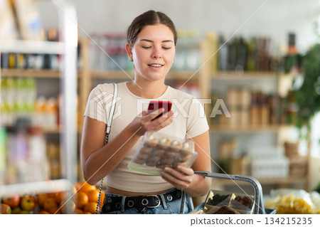Young woman scanning qr code of champignons Young woman scanning qr code of champignons 134215235