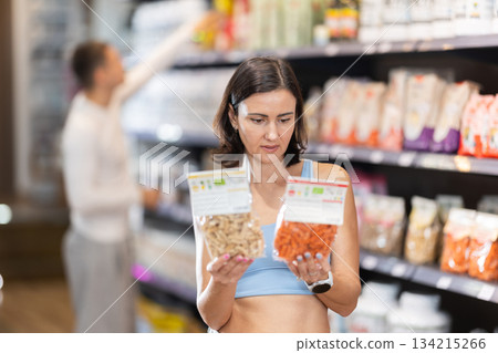Adult woman chooses healthy food in store Adult woman chooses healthy food in store 134215266