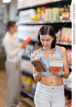 Adult woman chooses healthy food in store 134215283