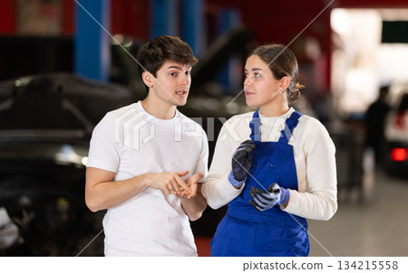 guy consults with a car service worker guy consults with a car service worker 134215558