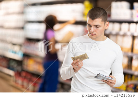 Young man chooses protein bar in store 134215559