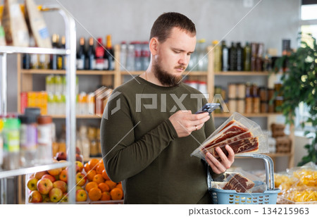 man scans ham in a store man scans ham in a store 134215963