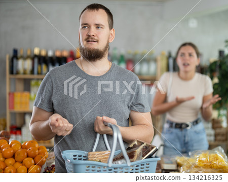 Young woman quarrels with man in grocery store Young woman quarrels with man in grocery store 134216325