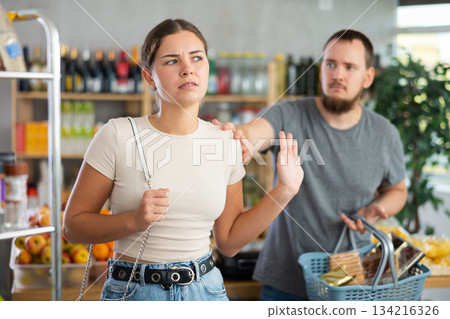 Husband calms his wife down after an argument in grocery supermarket, apologizing Husband calms his wife down after an argument in grocery supermarket, apologizing 134216326