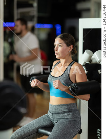 Woman training her hands in the machine Woman training her hands in the machine 134216444