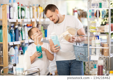 Schoolboy son and dad are choosing bast wisp and shower gel in store Schoolboy son and dad are choosing bast wisp and shower gel in store 134216462