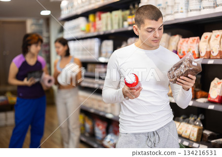 Young man chooses healthy bread and sports nutrition Young man chooses healthy bread and sports nutrition 134216531