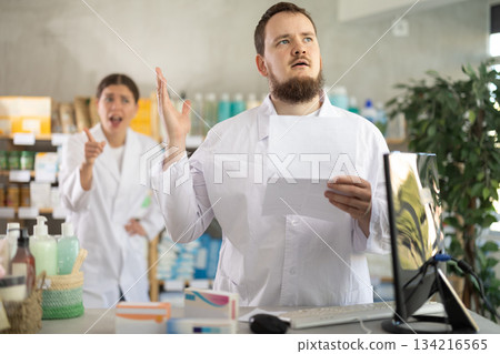 male pharmacist with documents in his hands in a pharmacy male pharmacist with documents in his hands in a pharmacy 134216565