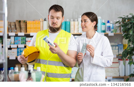 male builder chooses an ointment in a pharmacy male builder chooses an ointment in a pharmacy 134216568
