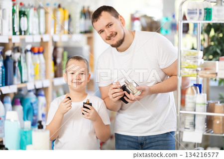 Dad and son client sniffs fragrance of perfume, chooses scent spray with pleasant smell Dad and son client sniffs fragrance of perfume, chooses scent spray with pleasant smell 134216577