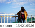 Woman in mustard jacket enjoying panoramic mountain view at Darjeeling View Point 134216586