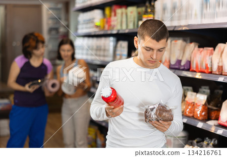 Young man chooses healthy bread and sports nutrition Young man chooses healthy bread and sports nutrition 134216761