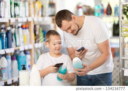 Man and boy scanning qr code for shampoo or shower gel 134216777