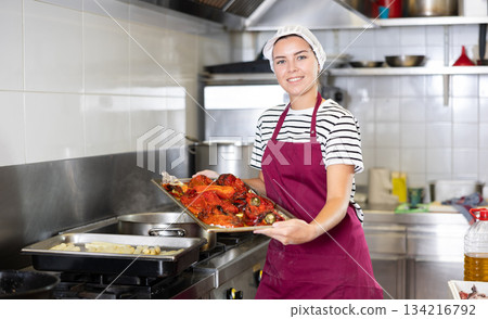 Female chef preparing vegetable dishes for sale in deli department 134216792