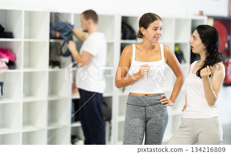 Two young women talking in locker room 134216809