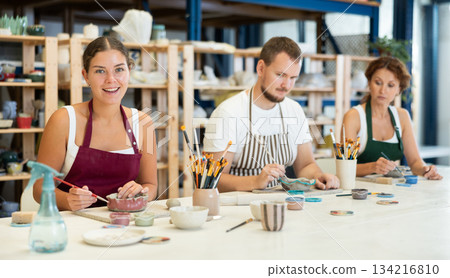 Three craftsperson are busy painting clay products 134216810