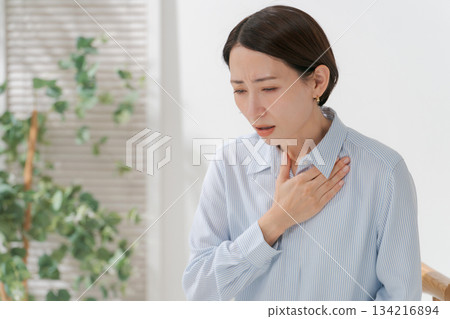 一名女子雙手摀著胸口，痛苦不堪。 134216894