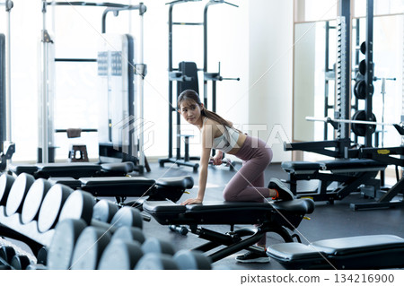 Young woman training in a sports gym Young woman training in a sports gym 134216900