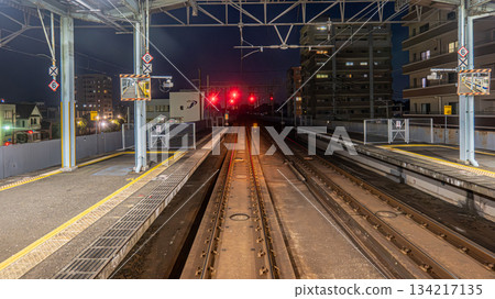 Train passing through a railroad crossing at night 134217135