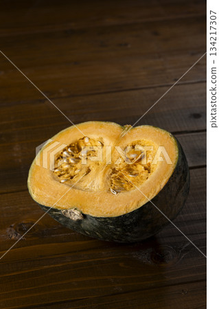 A vivid cross section of a cut pumpkin placed on a wooden table, creating a rustic food image A vivid cross section of a cut pumpkin placed on a wooden table, creating a rustic food image 134217307