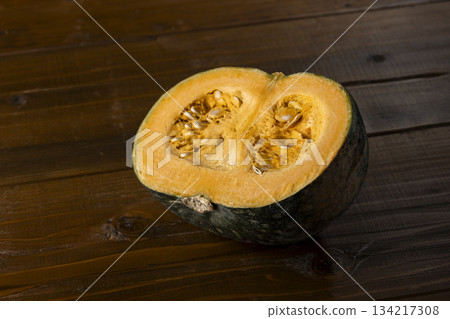 A vivid cross section of a cut pumpkin placed on a wooden table, creating a rustic food image A vivid cross section of a cut pumpkin placed on a wooden table, creating a rustic food image 134217308