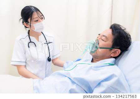 一名女護士正在照顧一名使用呼吸器的病人。 134217563