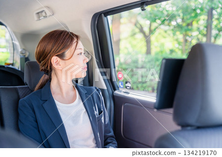 A career woman sitting in the back seat of a taxi A career woman sitting in the back seat of a taxi 134219170