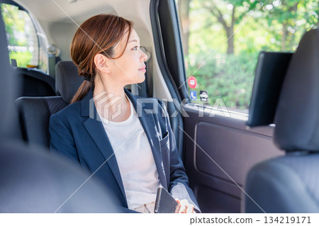 一位職業婦女坐在出租車後座。 134219171