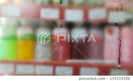 Blurry photo of bottled drinks on supermarket shelves 134219198