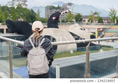 Happy woman traveler travel in Dujiangyan city. Tourist sightseeing Yangtianwo Square and Guanxian Ancient City near Chengdu. Landmark and popular for tourism attraction in Sichuan, China Happy woman traveler travel in Dujiangyan city. Tourist sightseeing Yangtianwo Square and Guanxian Ancient City near Chengdu. Landmark and popular for tourism attraction in Sichuan, China 134219807