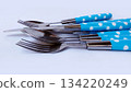 Cutlery in the form of a spoon, fork and knife with blue polka dot patterned handles. 134220249