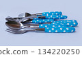 Cutlery in the form of a spoon, fork and knife with blue polka dot patterned handles. 134220250