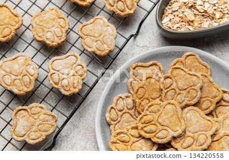 Homemade paw print dog treats cooling on rack 134220558