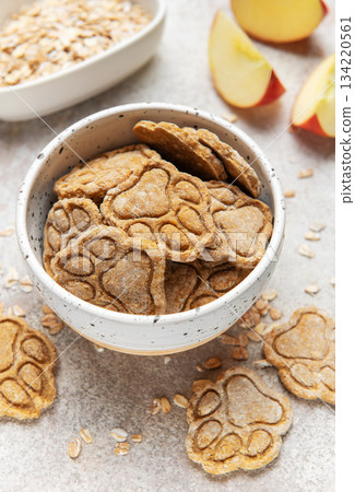 Homemade apple oat dog treats in speckled bowl 134220561