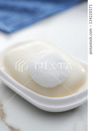 一張乾淨整潔的浴室照片，上面有泡沫豐富的香皂和整齊擺放的毛巾。 134220571